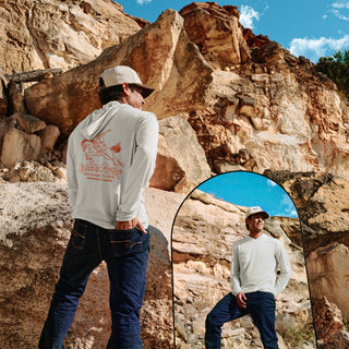 Man standing in front of a rocky cliff with a mirror reflection