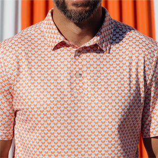 Close-up of the orange patterned Whataburger polo shirt with repeating "W" logo design.