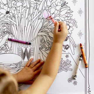 Coloring book with floral design and crayons on a white background
