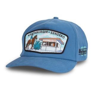 Blue cap with a patch featuring 'Whataburger x Sendero' design on a white background