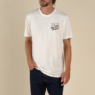 Man wearing a white t-shirt with text on a beige background