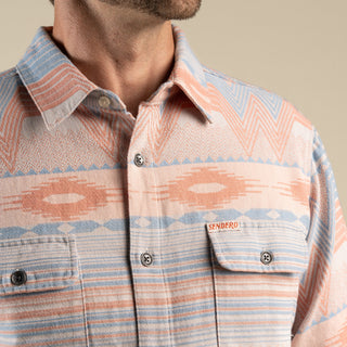Close-up of a patterned shirt with 'Sendero' branding on a beige background