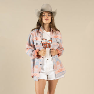 Woman wearing a plaid shirt, white shorts, and a cowboy hat on a beige background