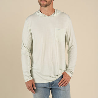 Man wearing a beige long-sleeve shirt with a pocket on a beige background