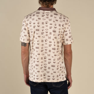 Man wearing a patterned shirt with a neutral background