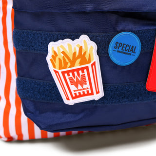 Close-up of the patches from the Whataburger Striped Patch Backpack, showcasing a fries patch, a blue "Special" circular day dot, and a red "Fancy Ketchup" square patch with white text.