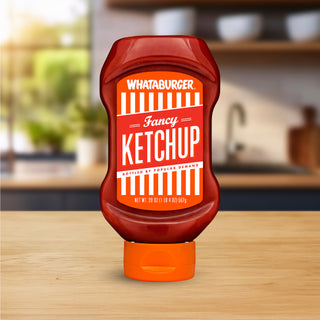 Whataburger Fancy Ketchup bottle placed on a wooden counter with a kitchen in the background.