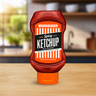 Whataburger Spicy Ketchup bottle on a wooden table with a blurred kitchen background