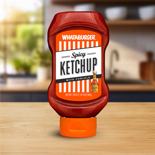 Whataburger Spicy Ketchup bottle on a wooden surface with a blurred kitchen background