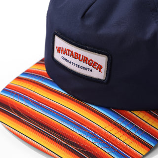 Navy blue cap with a 'Whataburger' logo on a colorful woven surface