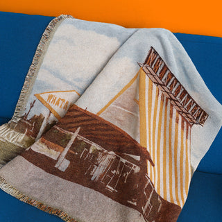 Woven blanket with rustic design on a blue and orange background