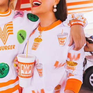 Person wearing Brianna Cannon x Whataburger sequin sweatshirt, holding a cup.