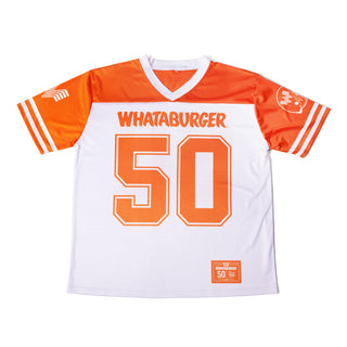 A white and orange football jersey laid flat on a white background, with 'WHATABURGER' across the chest and the number '50' in large orange block letters. The sleeves have white stripes, and there is a small neck label and a lower hem graphic.