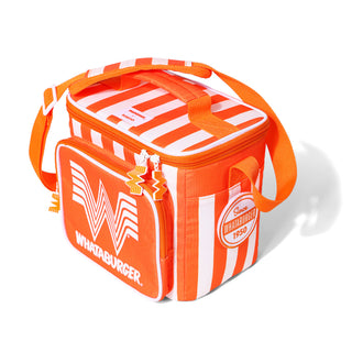 An orange and white striped Igloo x Whataburger cooler bag with a top handle, shoulder strap, and front zip pocket featuring the Whataburger logo.