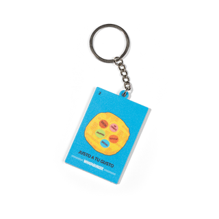 A rectangular keychain with a bright blue background and a yellow circular graphic showing small colored labels. The keychain has the text 'JUSTO A TU GUSTO' and 'WHATABURGER' printed on it, with a silver metal key ring and chain, photographed on a white background.