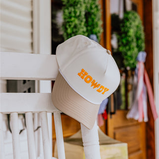 Tan hat with 'HOWDY' text and Whataburger logo on a white chair outdoors
