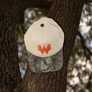 Flying W Camo Brim Hat hanging from branch of oak tree